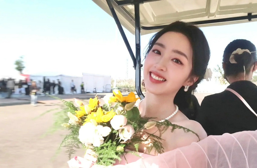 邓恩熙穿雾粉纱裙笑弯了眼，手捧花束又甜又灵动